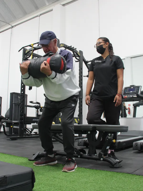 Terapeuta trabajando con adulto mayor en rehabilitación geriátrica